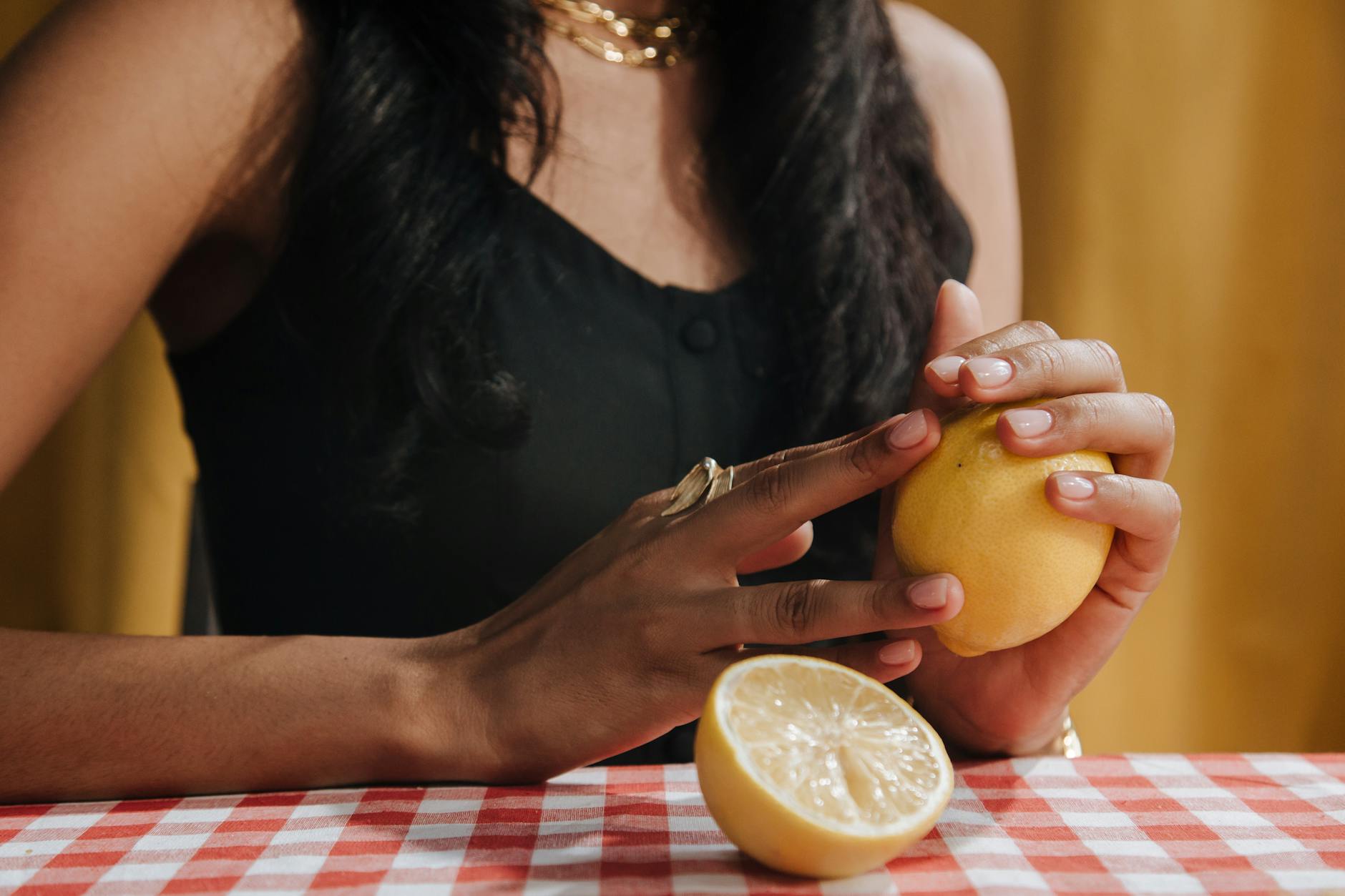 A yellow lemon vibrator surrounded by peeled bananas on a soft yellow background, representing gentle pleasure