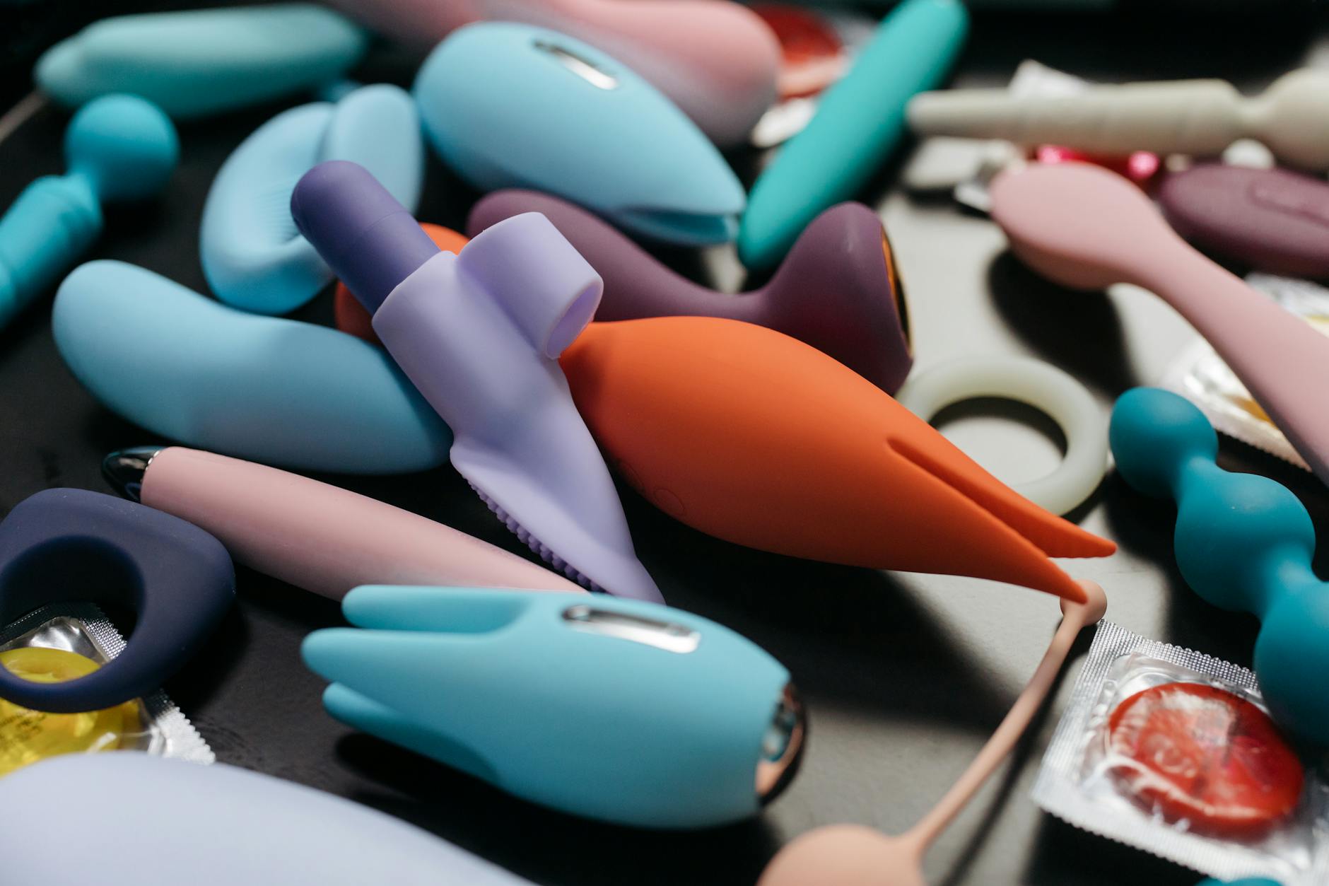 An array of vibrant clitoral vibrators and adult toys including lemon-shaped options in a close-up view.