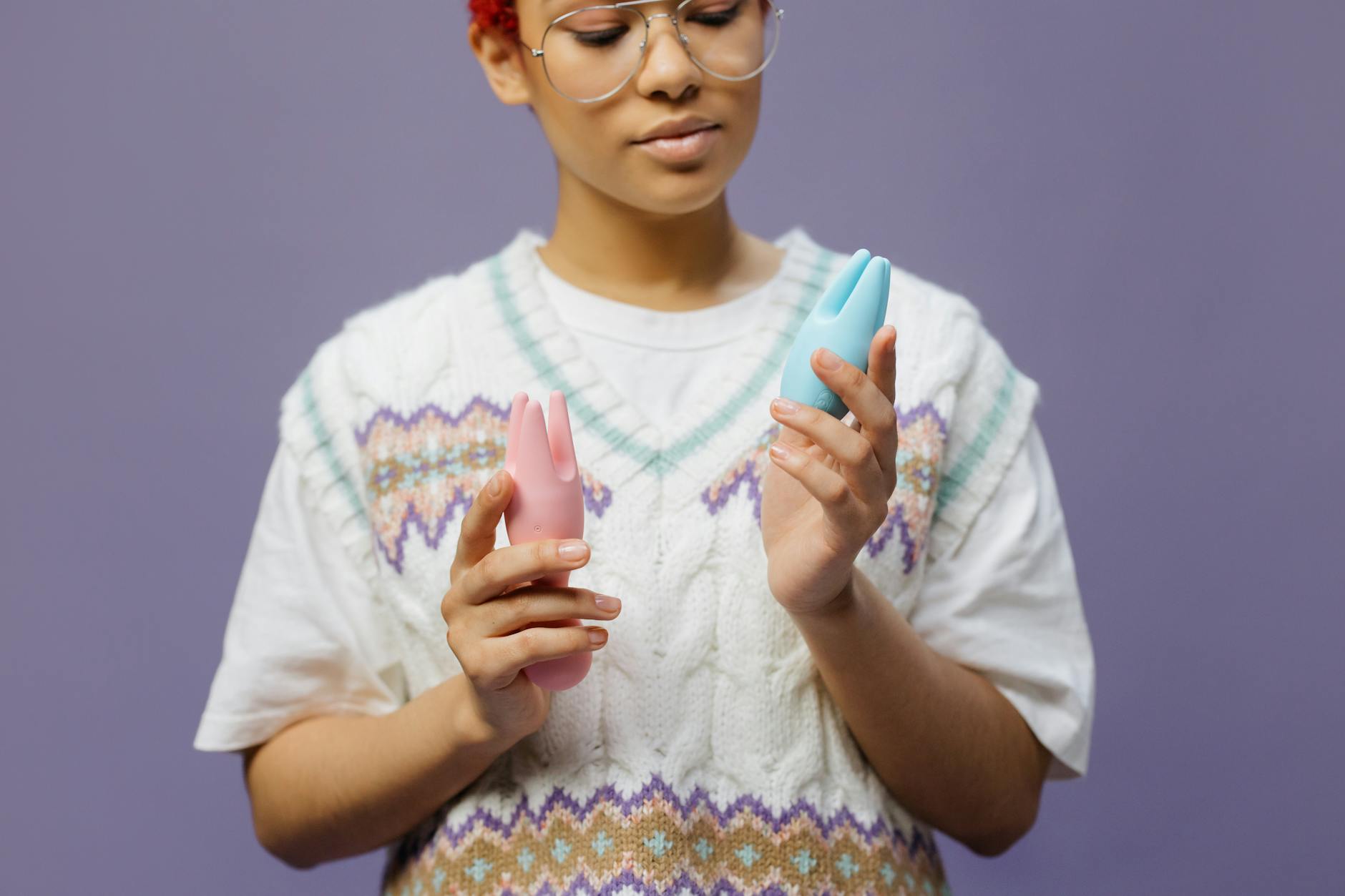 Woman thoughtfully comparing vibrator options and air suction devices