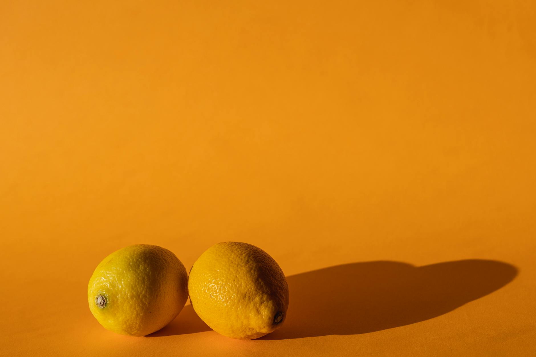 Bright yellow lemons on a pastel background, representing freshness and vitality